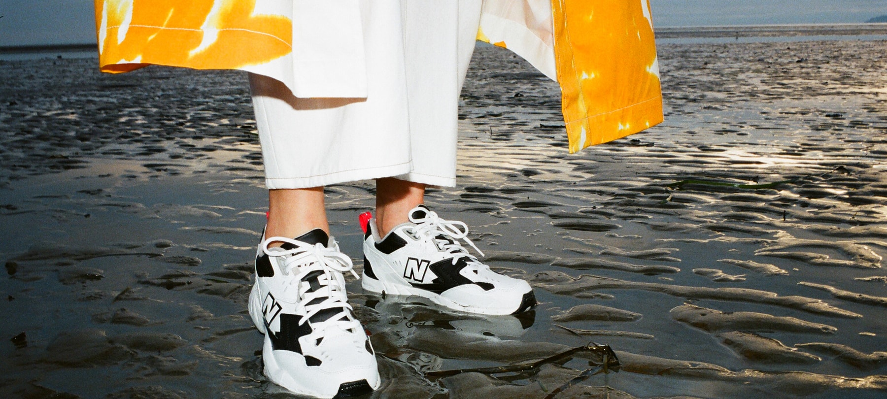 New Balance Sneakers Sneaker Spring Summer 2019 608v1 Black White Dries Van Noten Orange Coat White Pants Editorial Beach Sand Golden Hour