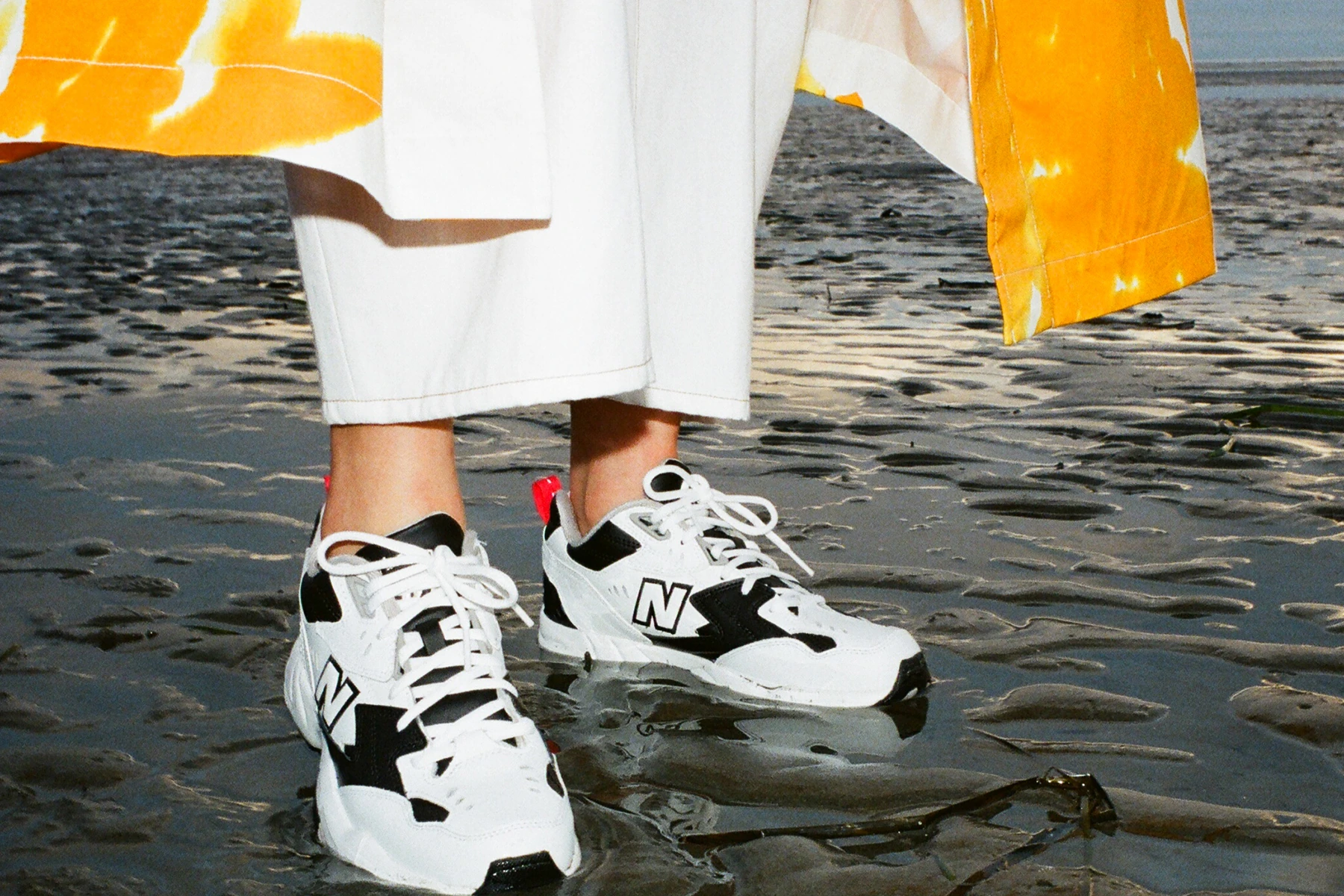 New Balance Sneakers Sneaker Spring Summer 2019 608v1 Black White Dries Van Noten Orange Coat White Pants Editorial Beach Sand Golden Hour