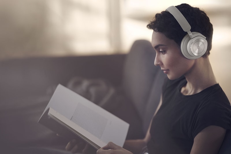 bang and olufsen beoplay hx headphones listening music sand beige reading book