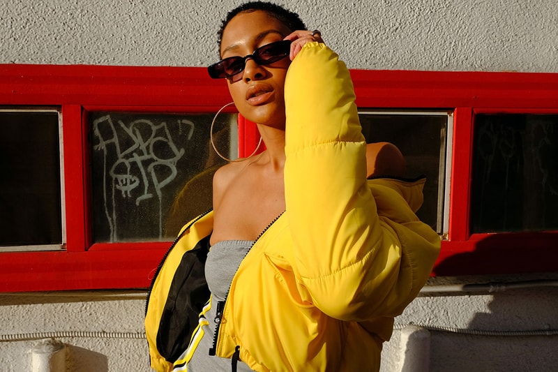 Gen Z woman holding sunglasses and posing