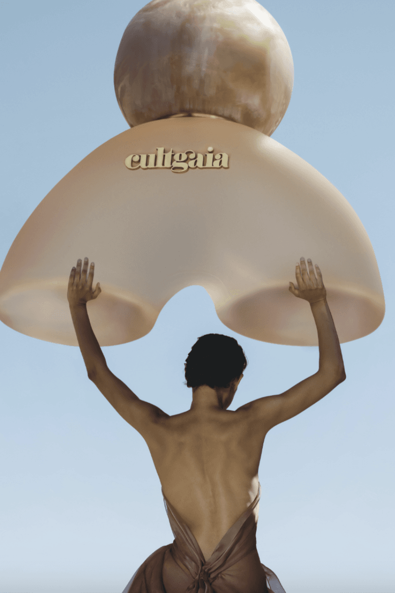 woman lying down in desert in sage colored dress, cult gaia, fragrance launch