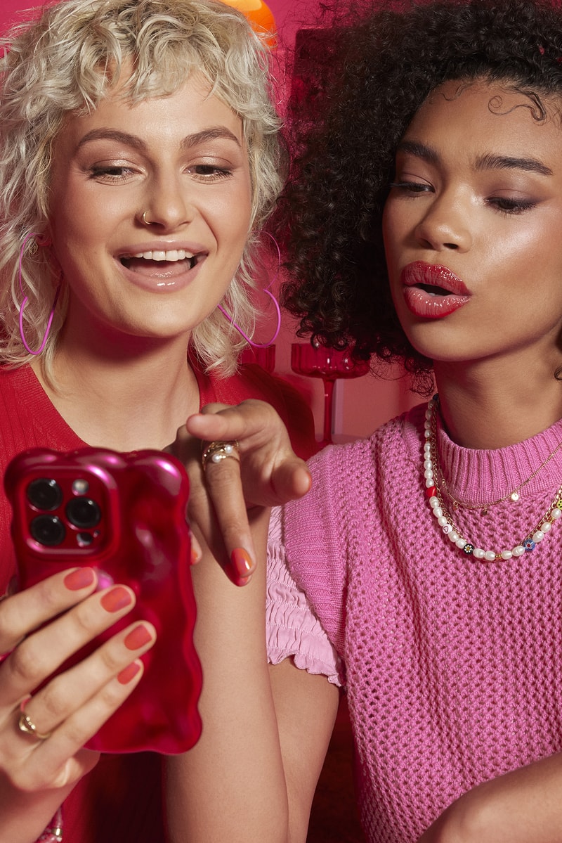 woman applying lip gloss in a red room, tinder and e.l.f. cosmetics collab, makeup, beauty