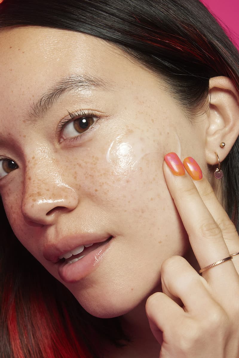 woman applying lip gloss in a red room, tinder and e.l.f. cosmetics collab, makeup, beauty