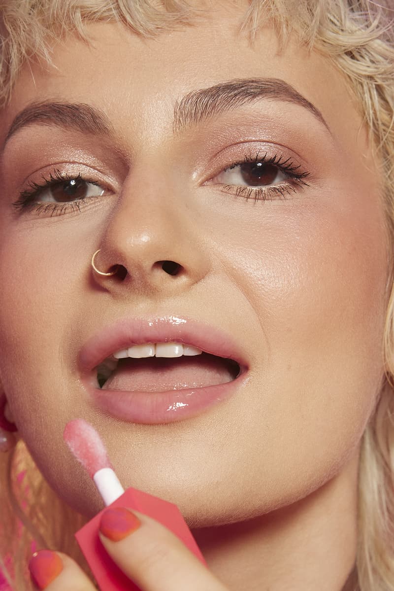 woman applying lip gloss in a red room, tinder and e.l.f. cosmetics collab, makeup, beauty