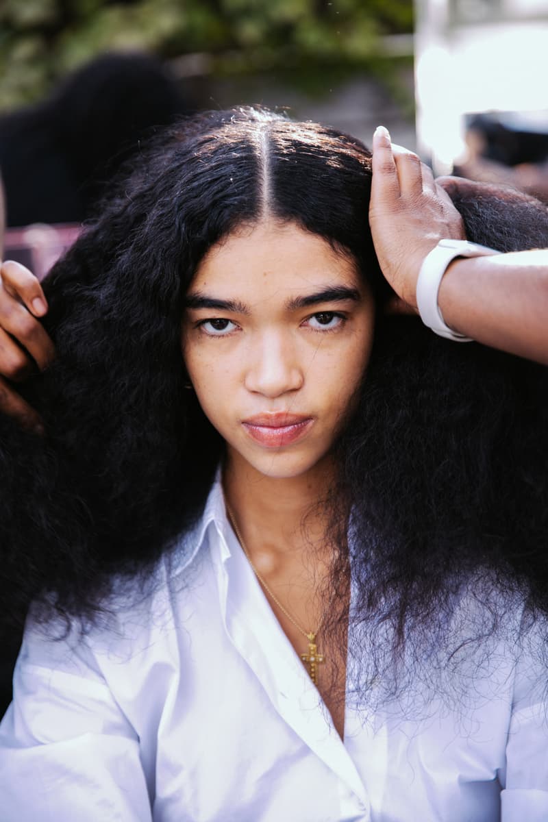 woman getting her curly hair done by two people, laquan smith, mac cosmetics, camille rose, hair, makeup, fashion week