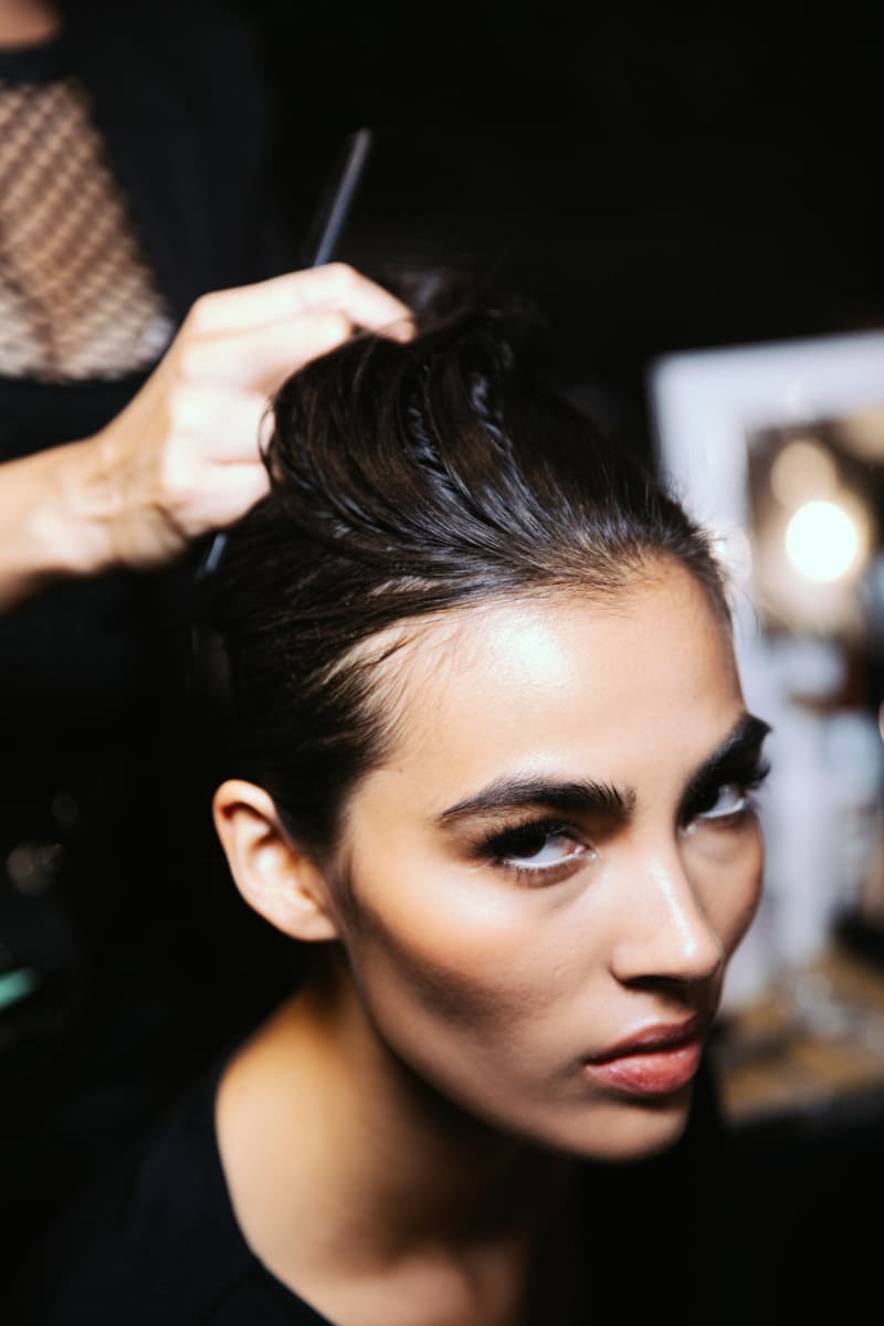 woman getting her curly hair done by two people, laquan smith, mac cosmetics, camille rose, hair, makeup, fashion week