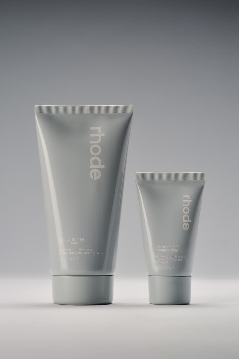 claudia schiffer in black sunglasses posing with rhode barrier butter, beauty launch, skincare, hailey bieber