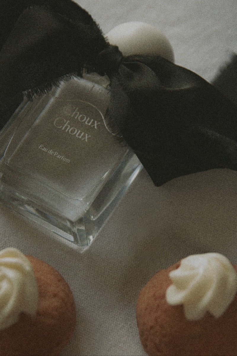 fragrance laid out on table with pastries, bow, fragrance 