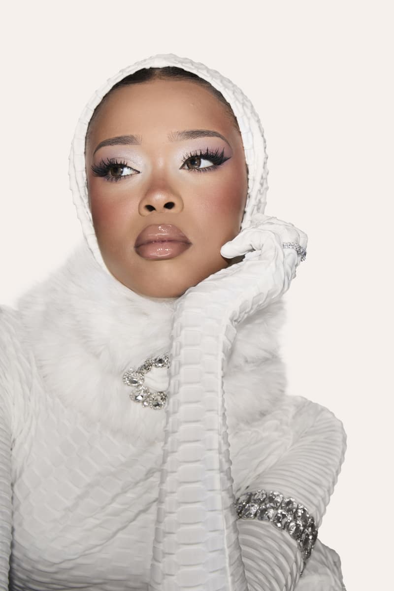 huda kattan posing with "icy nude" eyeshadow palette, huda beauty, makeup, middle east 