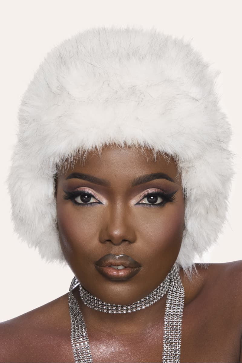 huda kattan posing with "icy nude" eyeshadow palette, huda beauty, makeup, middle east 