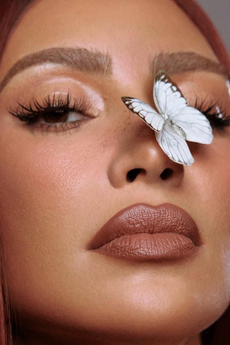 kim kardashian posing with red hair and new skkn by kim matte lipstick, makeup, skincare, kardashians