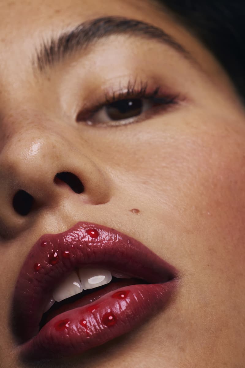 woman posing on top of a convertible with glossier balm dot com in her hand, black cherry collection, makeup, skincare