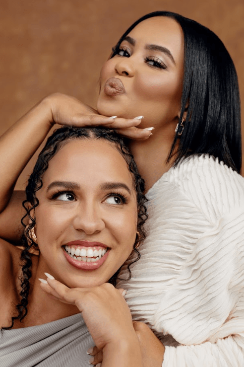 woman with braided knots on top of her head posing in orange dress, i see you, rare beauty makeup campaign