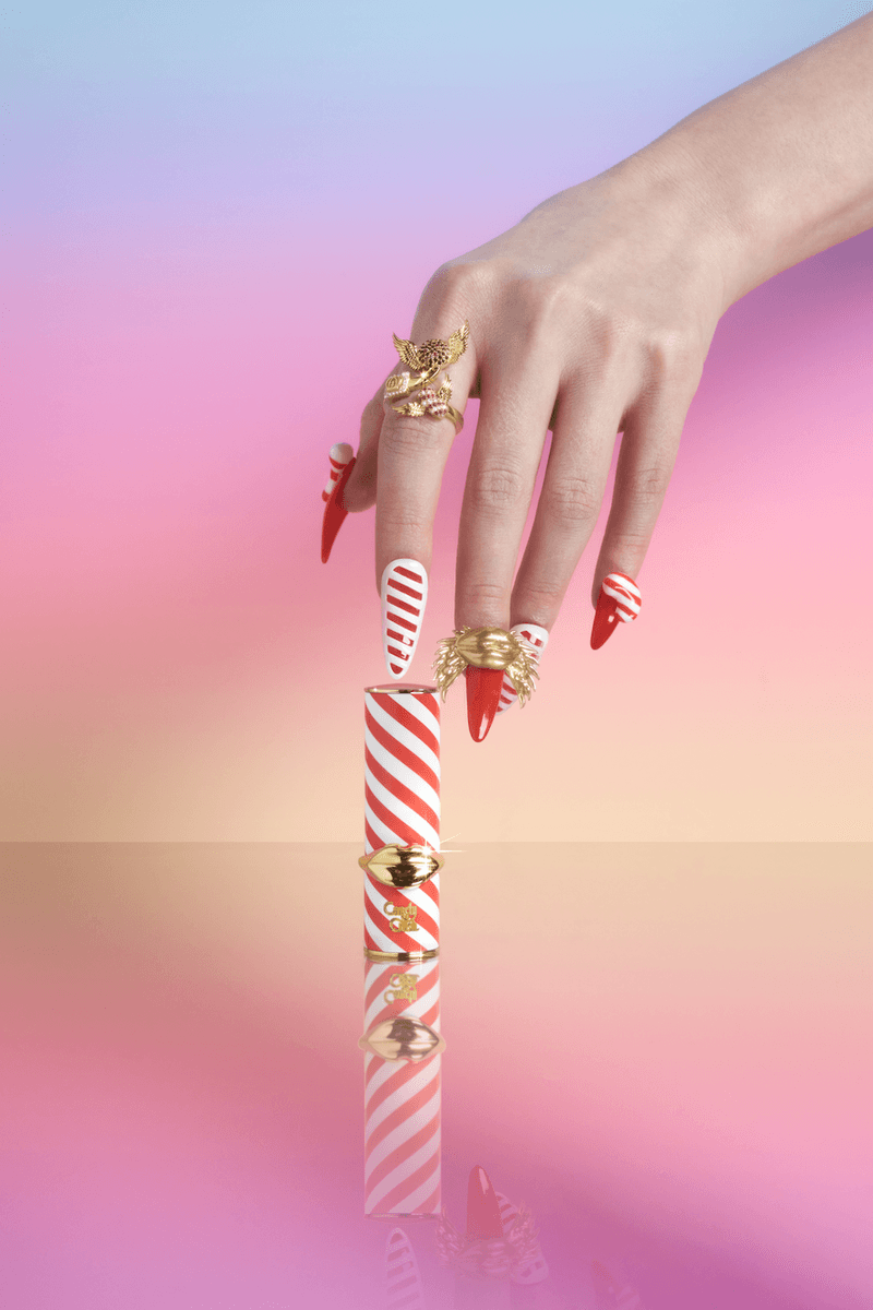 photo of a candy with candy cane design nails wearing nice diamond jewelry with a lipstick, diamond-encrusted ring, candy crush and pat mcgrath labs makeup collaboration, beauty