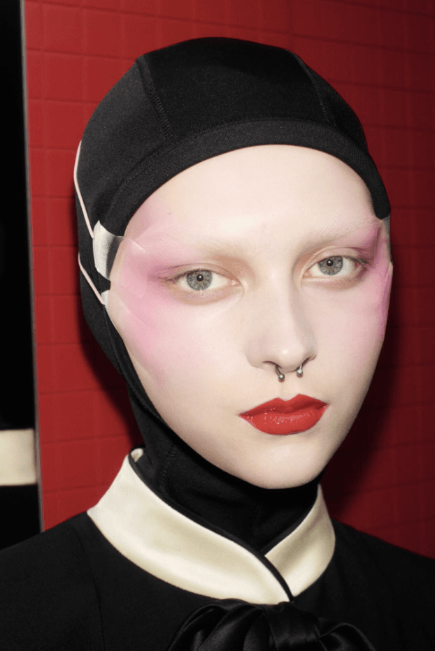 two models at valentino paris fashion week show fall/winter 2025 wearing pink blush and face tape, beauty, makeup