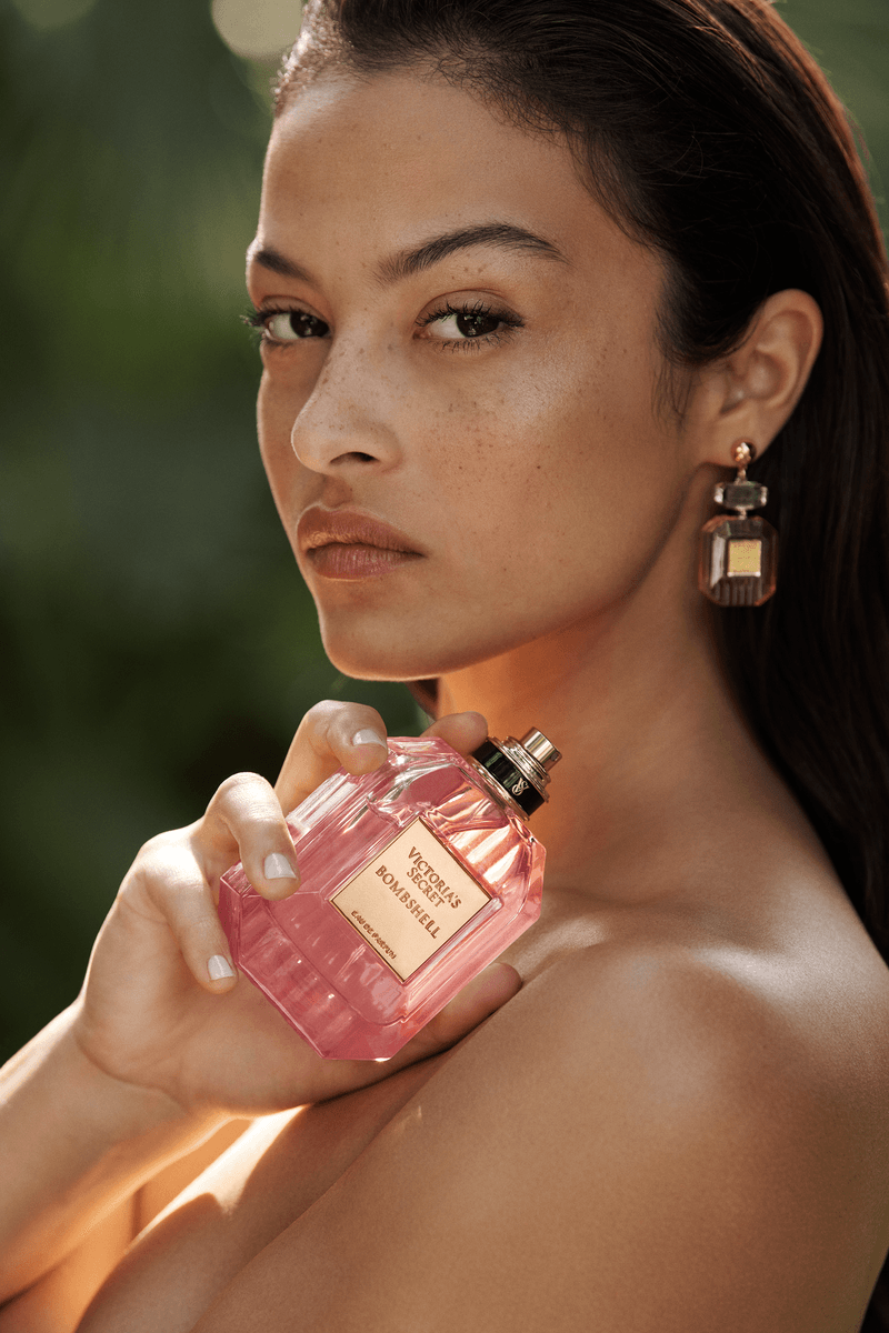 model devyn garcia holding a supersized bottle of victoria's secret bombshell perfume, fragrance, beauty