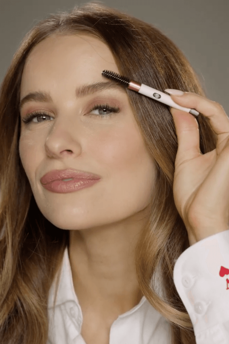 woman brushing her eyebrow hair with brush, dyson haircare tools, beauty