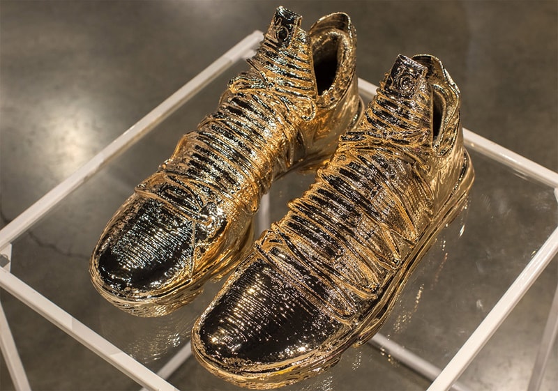 Kevin Durant Nike KD 10 “Art Of A Champion” Gold dipped NBA Golden State Warriors special suitcase alongside merchandise KD artwork 16 slash mark hangtag