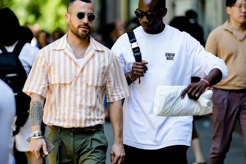 milan fashion week street style spring summer 2019 know wave tee graphic white shirt clutch bag grey green white striped shirt tucked in khaki pants