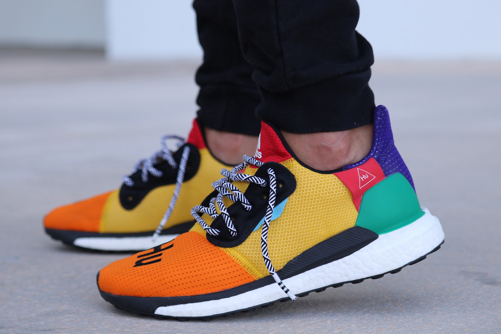 Pharrell adidas Solar Hu Glide ST Early Look rainbow colorway boost midsole yellow orange blue pink black white green pattern laces collaboration drop on foot side black