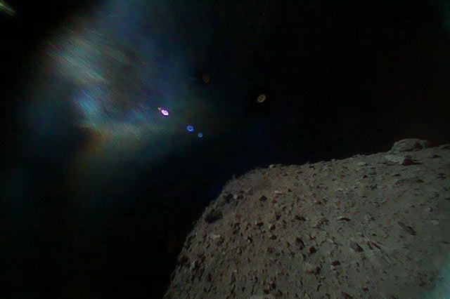 japan asteroid space robot rover rovers two 2 asteroids images photos jaxa 1a 1b Hayabusa 2 rocks soil crater denote explosive center sun solar glare