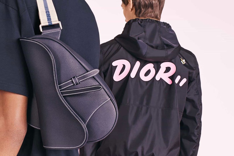 dior menswear kim jones kaws bee collaboration capsule collection release date body bag leather saddle logo track jacket print strap branding blue navy tee shirt