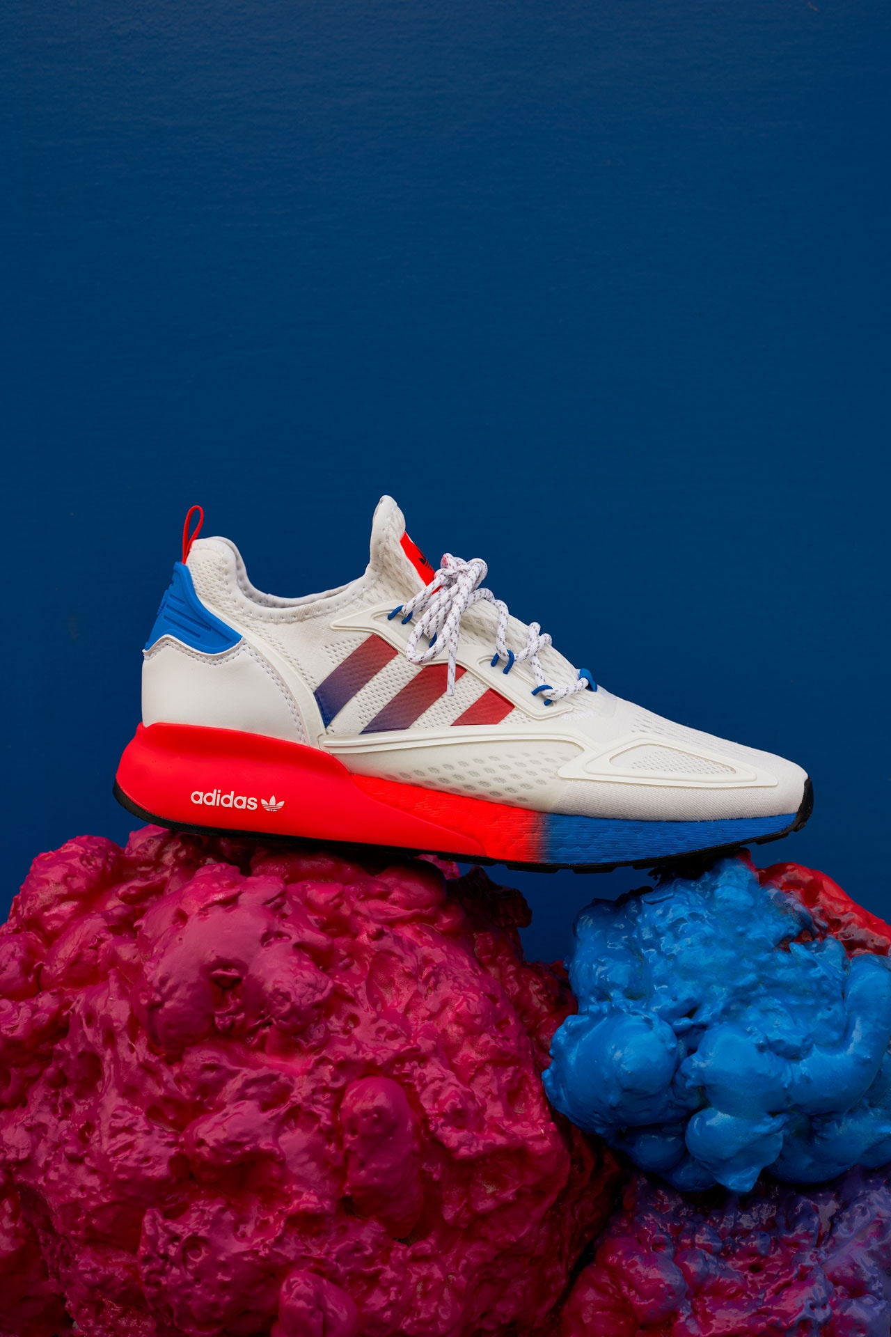 Oddly satisfying design and technology Zxience Network Ninja flexibility Sean Wotherspoon color gradients Mette Towley comfort actor Ranveer Singh squishiness Stream of ConZXiousness Adiprene X outsole solar red shock pink Stark Blue gradient sole white mesh upper black striples blue accents BOOST technology ombre colour palette toe to heel