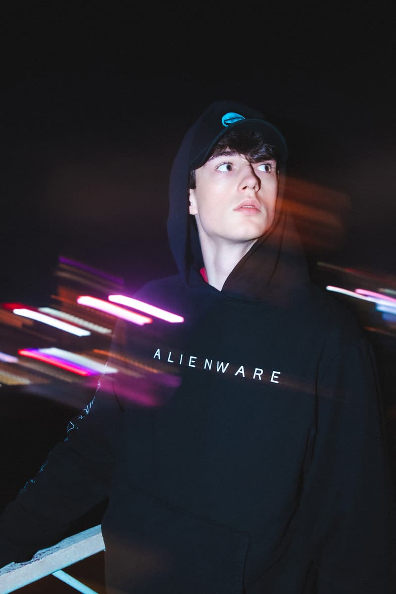 Alienware HBX lookbook shots merch debut graphics design First Contact concept assortment selection of t-shirts, long sleeves, hoodies and hats postmodern aesthetic scanned topographical Alienware head reflective logos, laptop exploding holographic effects, custom typefaces and fonts, internal molecular structure vessels along  the sleeves and Alienware Circuit Head graphics with Chrome Glow cyber blue + grey and neon green + purple washed grey olive 2 color print coordinates and dimensional structures neon green, bright orange and purple Alienware's mapping effects, technical-wear focus and radar monitors hoodie neon green space grey digital gateway black electric blue hat made in the USA with premium Flexfit tech material