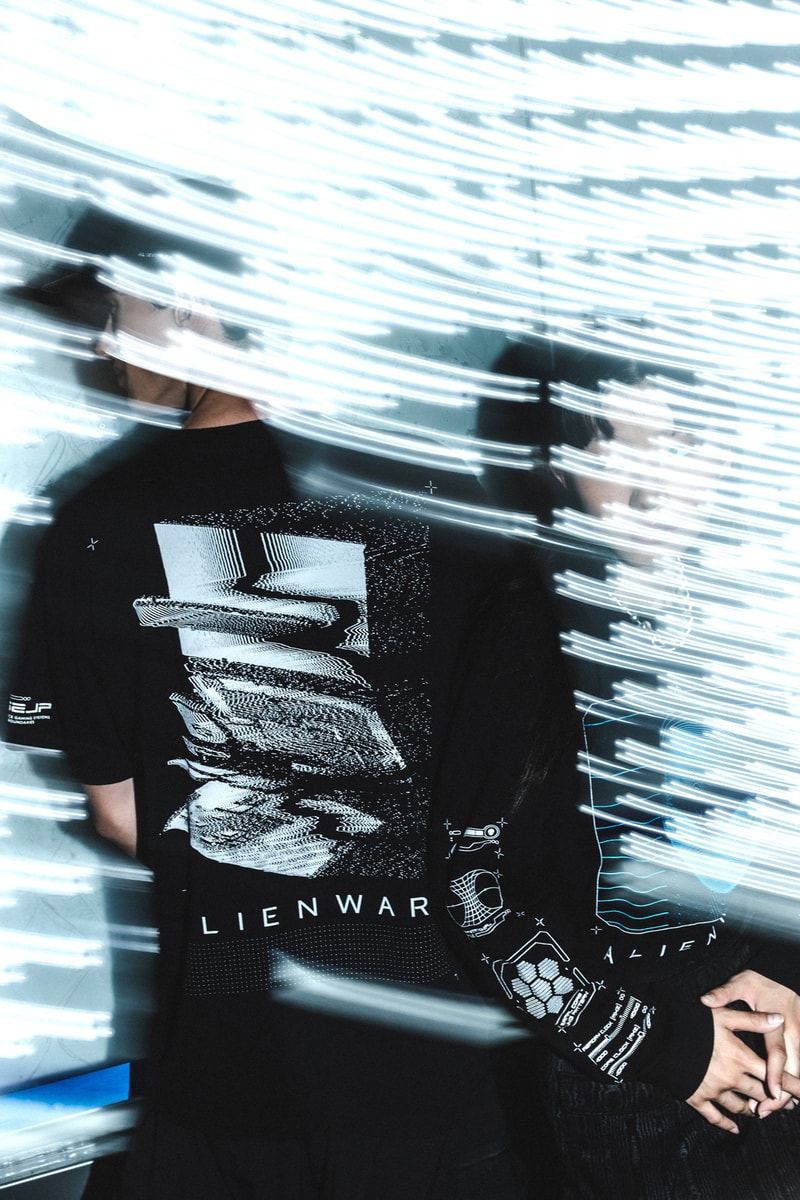 Alienware HBX lookbook shots merch debut graphics design First Contact concept assortment selection of t-shirts, long sleeves, hoodies and hats postmodern aesthetic scanned topographical Alienware head reflective logos, laptop exploding holographic effects, custom typefaces and fonts, internal molecular structure vessels along  the sleeves and Alienware Circuit Head graphics with Chrome Glow cyber blue + grey and neon green + purple washed grey olive 2 color print coordinates and dimensional structures neon green, bright orange and purple Alienware's mapping effects, technical-wear focus and radar monitors hoodie neon green space grey digital gateway black electric blue hat made in the USA with premium Flexfit tech material