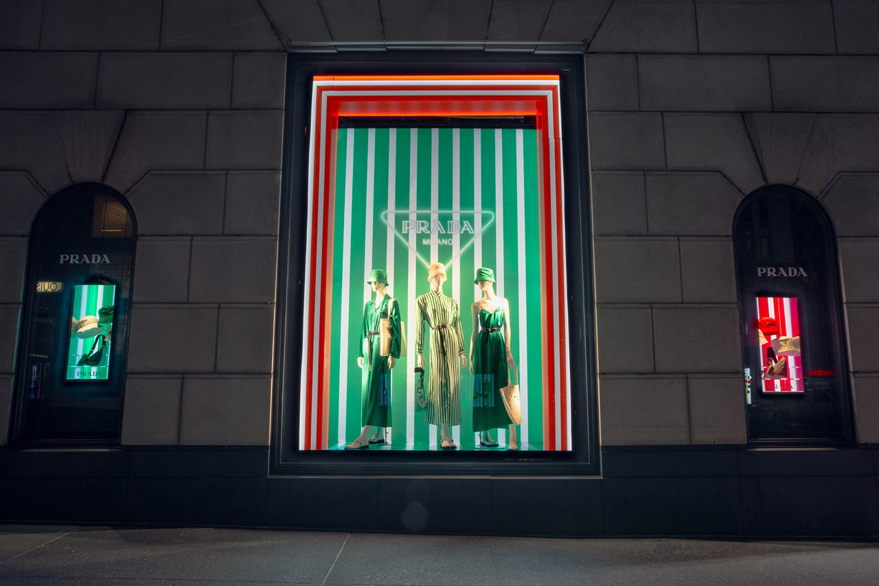 Spring Summer 2022 Collection Prada Tropico Hypnotic Window Light Installation Bergdorf Goodman Department Store Refracted Multicolored Lights Luxury Fashion Experiential Storefront Vertical Diagonal Lines Hues Green Orange Red Bright Vivid Nylon Striped Dresses Blouses Shoes Rubber Sandals Bucket Hats Raffia Handbags Pajama Sets Tropical Rainbow 