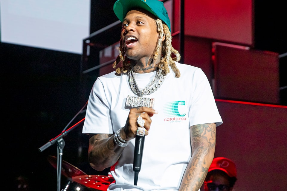 Download Lil Durk poses in a stylish outfit against a vibrant background