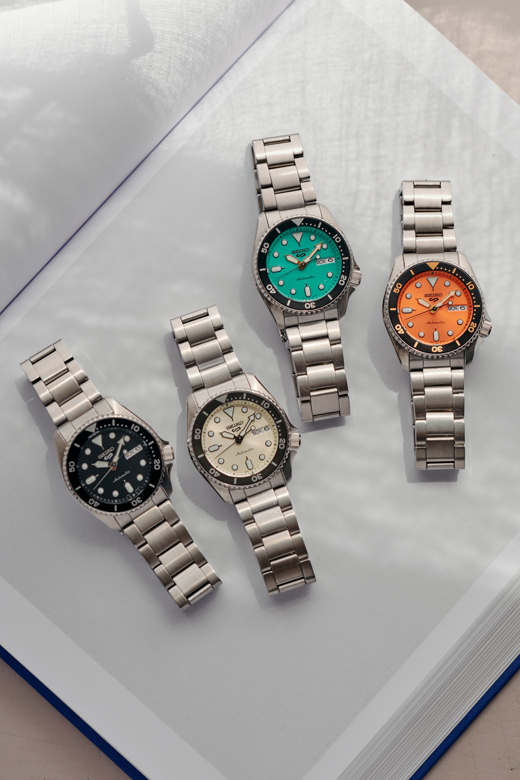 Seiko Expands 5 Sports Watch Line With Mid-Size Model SKX Japanese timepiece steel bracelet orange champagne black teal