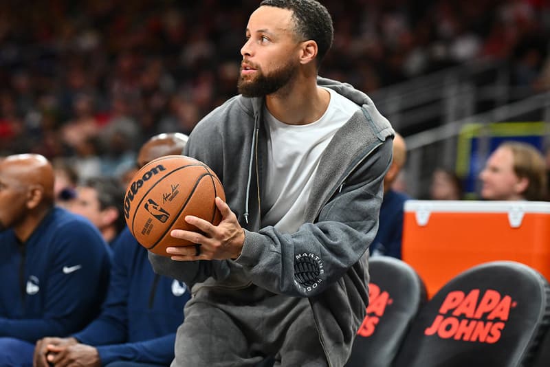Steph Curry wearing an unannounced Google Fitbit screenless fitness band with a gray woven strap and orange piping
