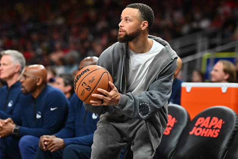 Steph Curry wearing an unannounced Google Fitbit screenless fitness band with a gray woven strap and orange piping
