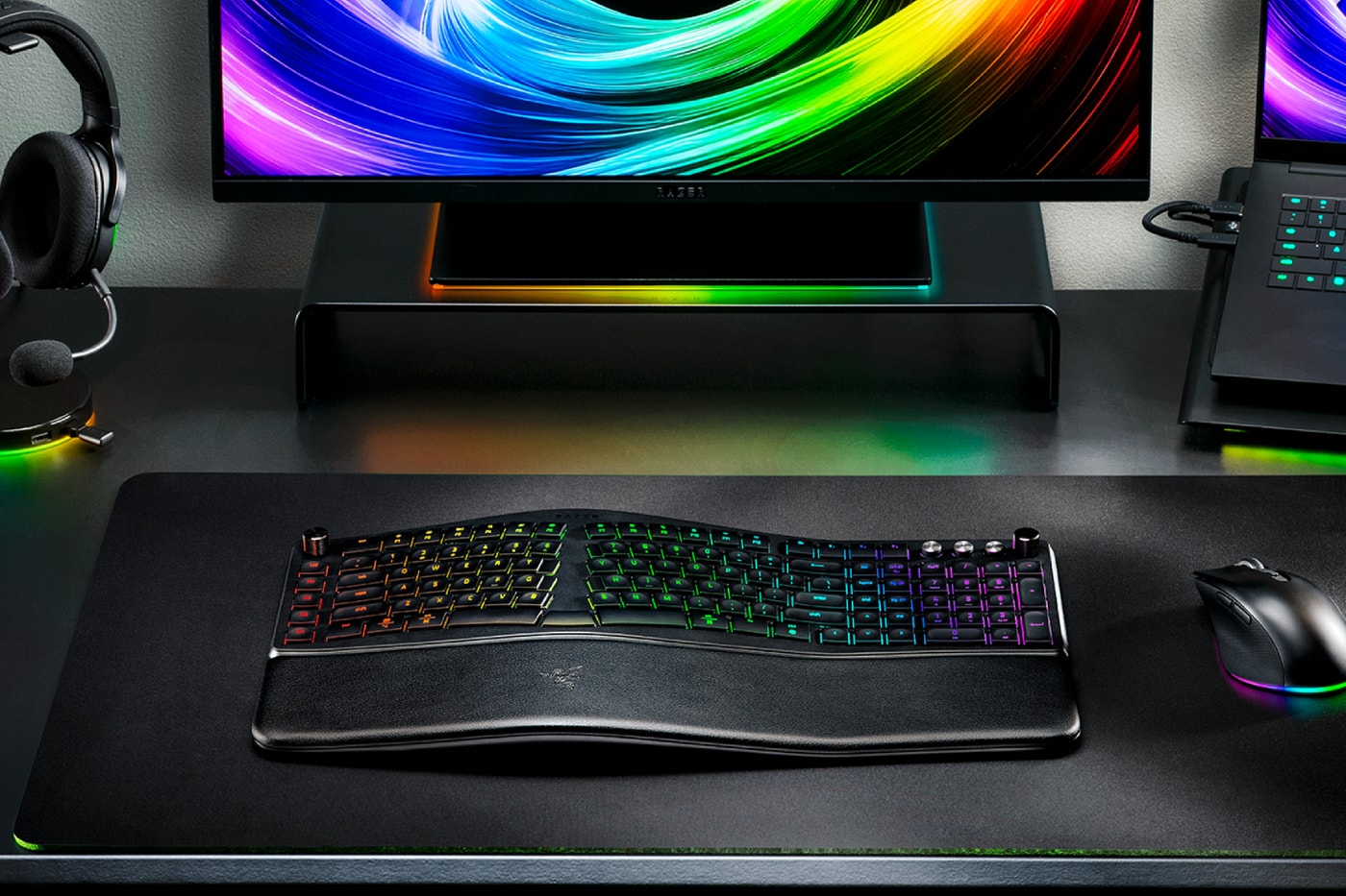 Razer Pro Type Ergo wireless ergonomic keyboard with split Alice-style layout, wrist rest and RGB lighting on a modern desk setup.