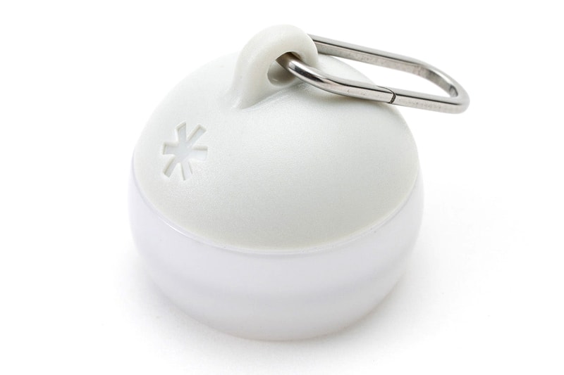 Snow Peak Micro Hozuki mini lantern clipped to a backpack strap, showing compact waterproof LED design