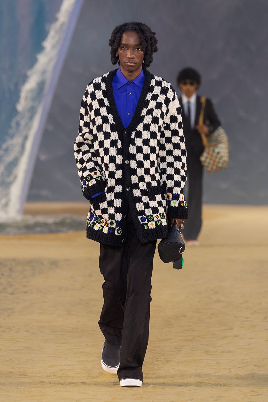 Model walks the moonlit sand runway at Louis Vuitton SS27 show