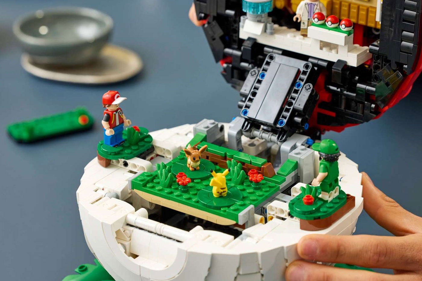 LEGO's "Iconic Trainer Moments" Poké Ball Is a Masterclass in Hidden Brick Construction first-ever human Pokémon minifigures collaboration pokemon professor oak famous laboratory
