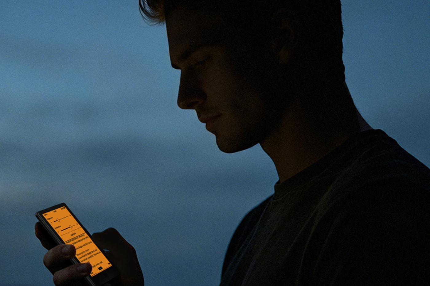 Xteink X4 Pro pocket e-reader with dual-tone frontlight attached magnetically to a smartphone