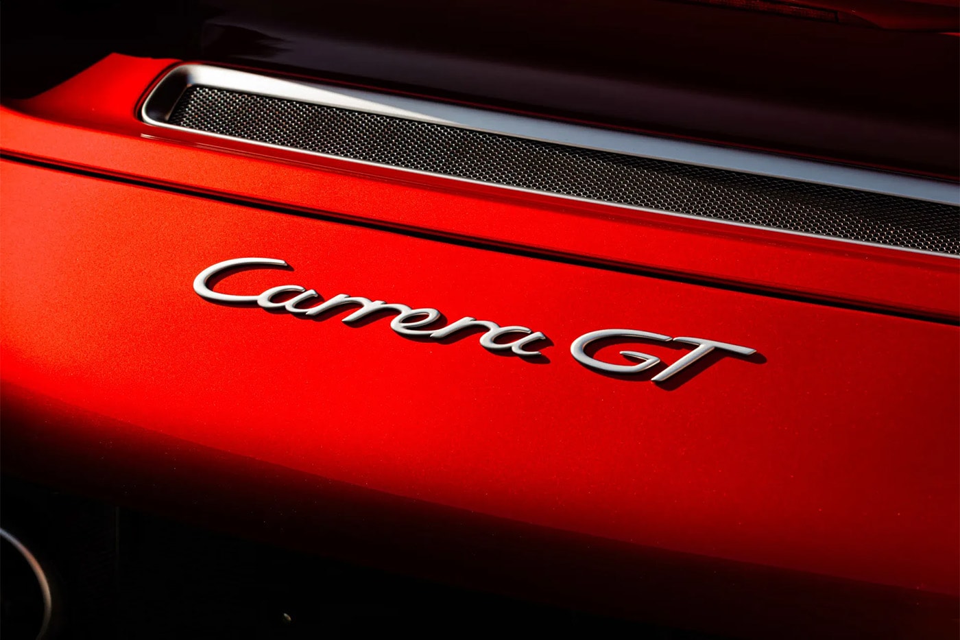 Porsche Carrera GT in Ferrari Rosso Fuoco at Mecum Monterey auction lot display