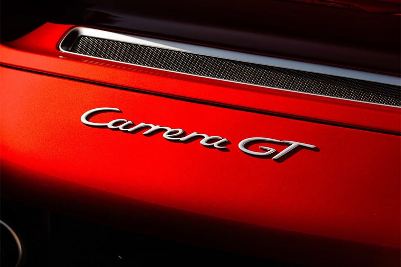 Porsche Carrera GT in Ferrari Rosso Fuoco at Mecum Monterey auction lot display