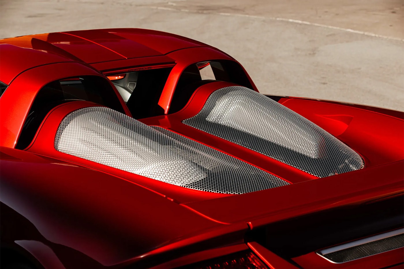 Porsche Carrera GT in Ferrari Rosso Fuoco at Mecum Monterey auction lot display