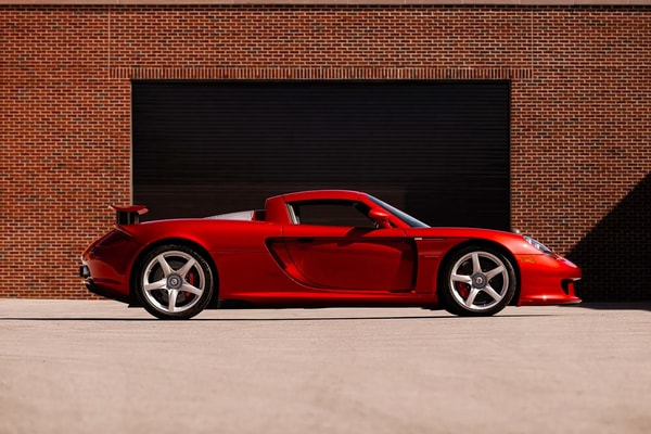 Porsche Carrera GT in Ferrari Rosso Fuoco at Mecum Monterey auction lot display