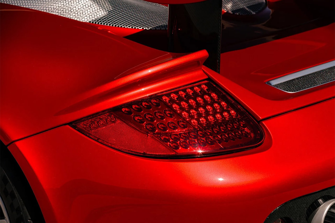 Porsche Carrera GT in Ferrari Rosso Fuoco at Mecum Monterey auction lot display