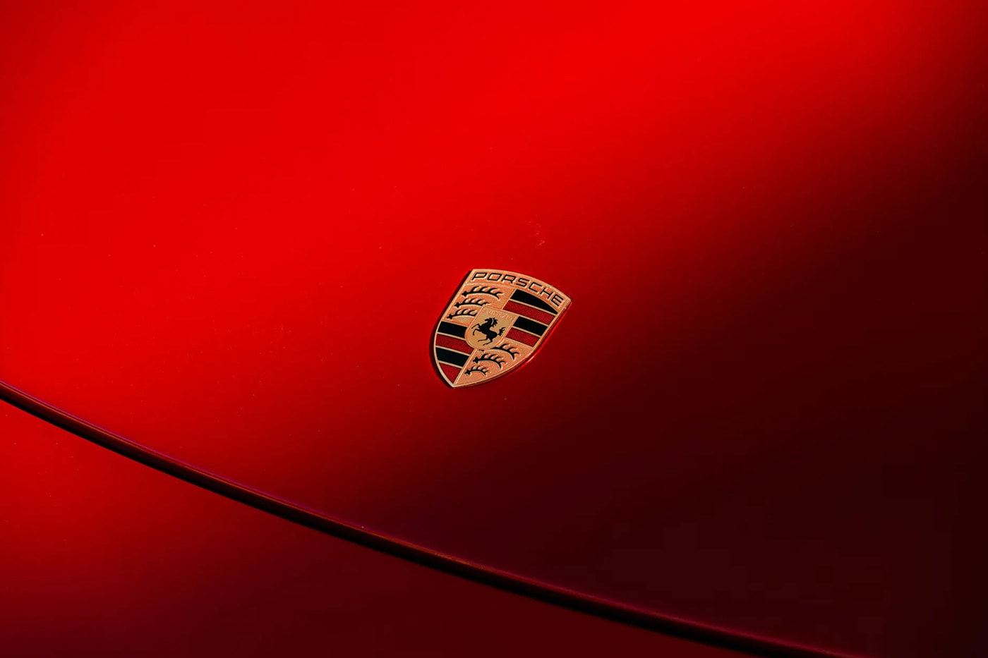 Porsche Carrera GT in Ferrari Rosso Fuoco at Mecum Monterey auction lot display