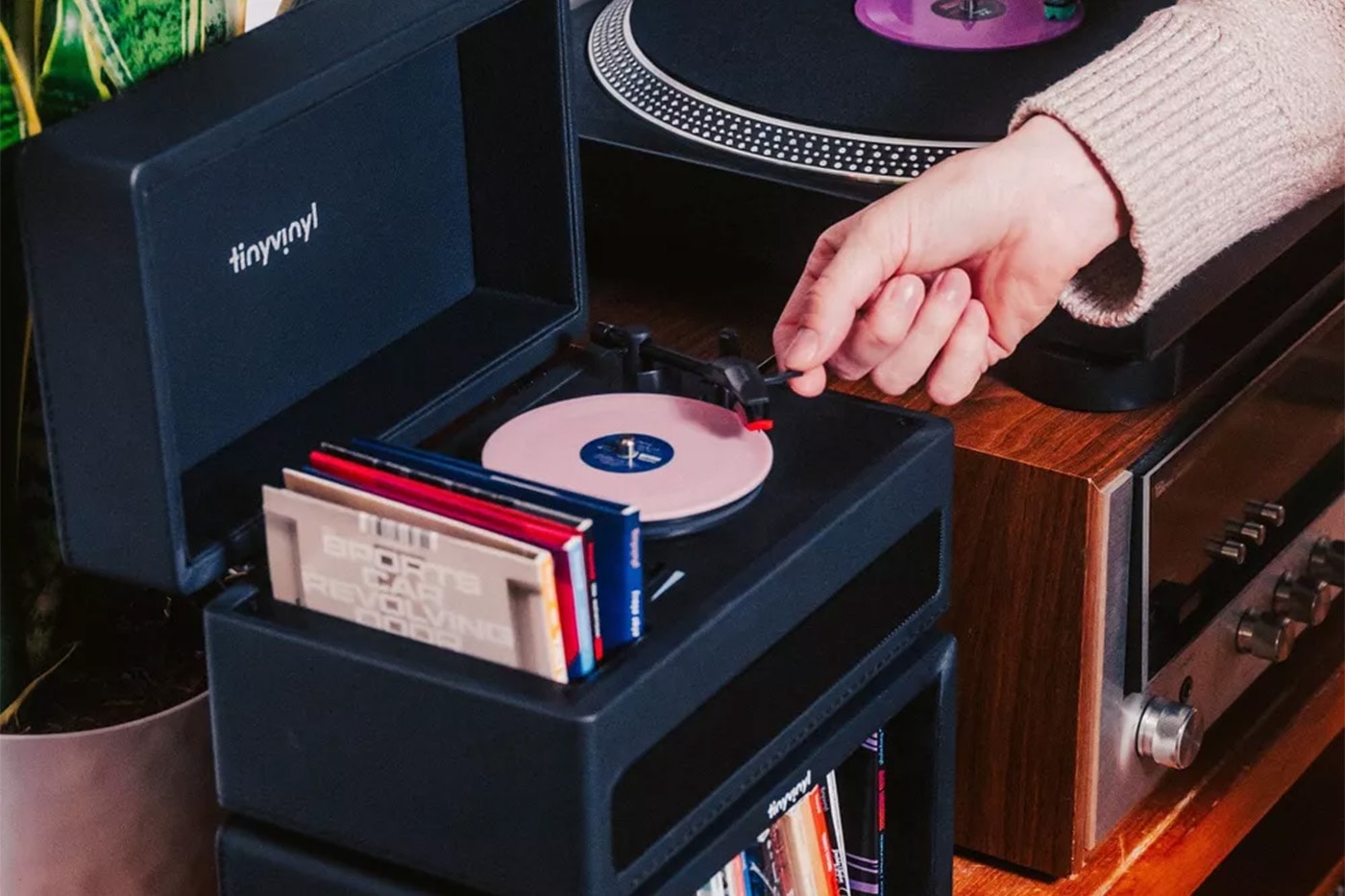 Tiny Vinyl player turntable spinning four-inch records with black leatherette suitcase design