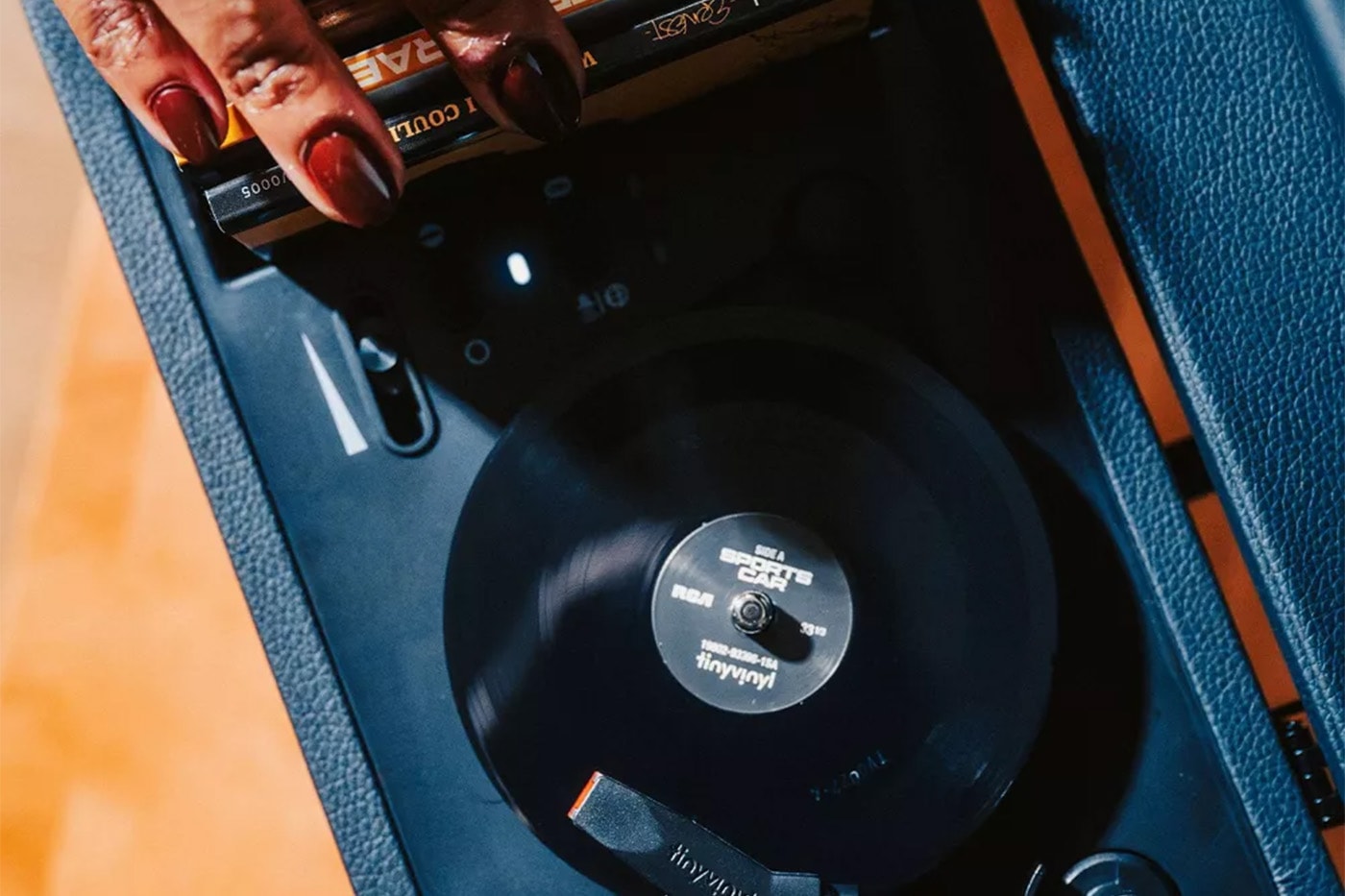 Tiny Vinyl player turntable spinning four-inch records with black leatherette suitcase design