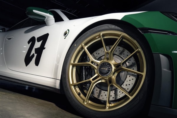 Porsche 911 GT3 100 Jahre Nürburgring in Green Hell livery with gold center-lock wheels on track