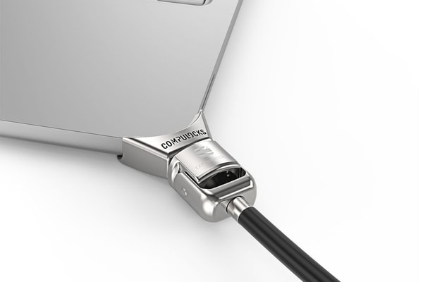 CompuLock Ledge lock adapter clamped to a MacBook Neo corner with cable lock attached