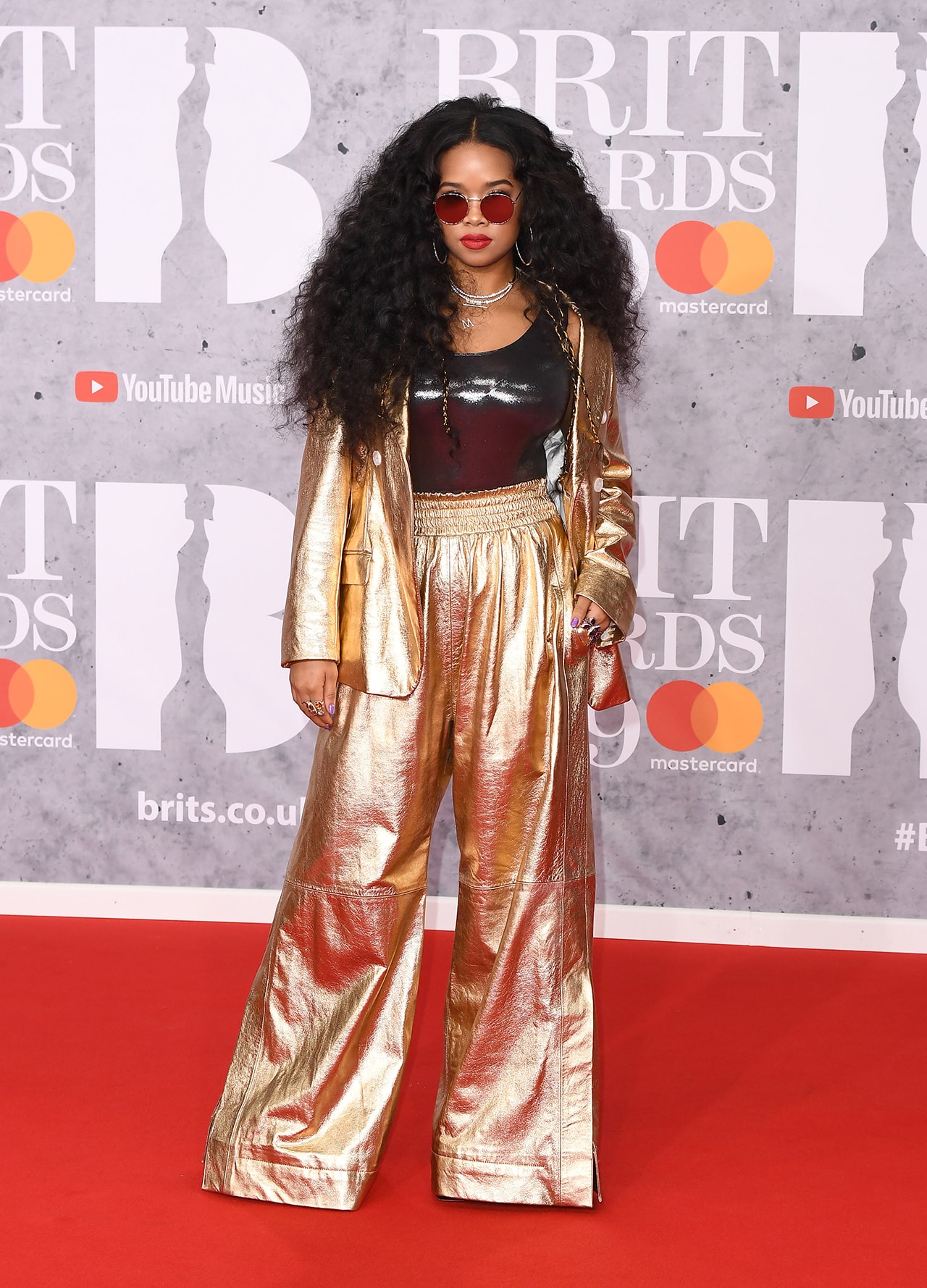 H.E.R HER Brit awards 2019 red carpet metallic gold suit sunglasses